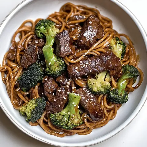 Eine Schüssel Nudeln mit zartem Rindfleisch und Brokkoli, bestreut mit Sesam.