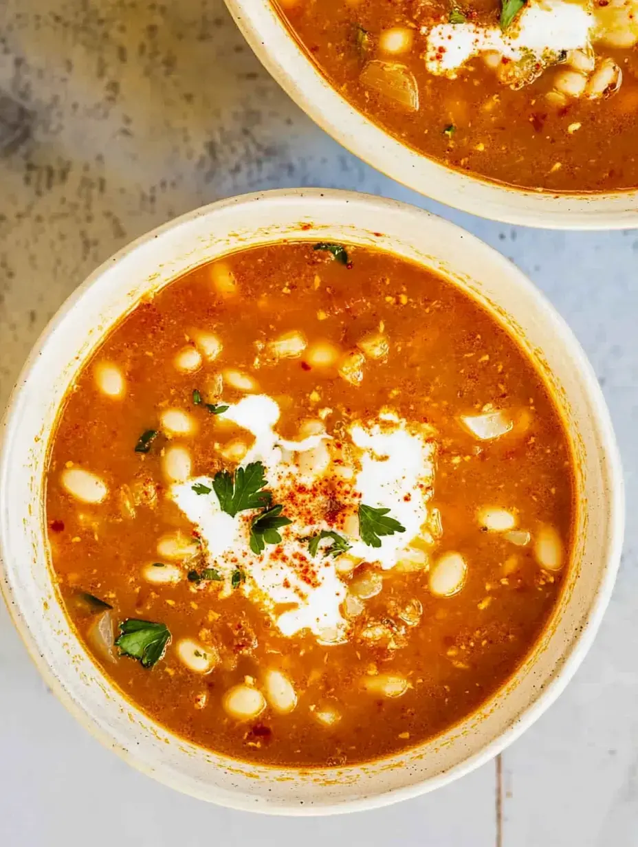 Zwei Schalen Suppe getoppt mit Sauerrahm, Petersilie und Gewürzen aus der Nähe.