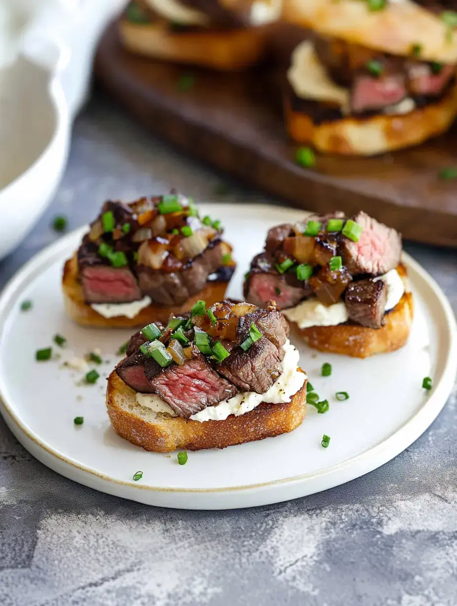 Ein Teller mit geröstetem Brot, belegt mit Rindfleisch, cremiger Sauce, karamellisierten Zwiebeln und gehacktem Schnittlauch.