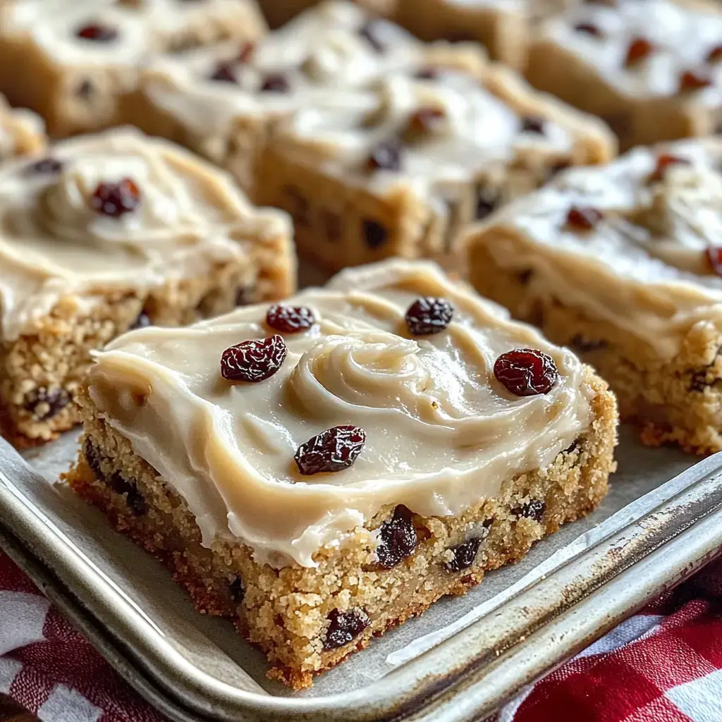 Nahaufnahme von Dessertstücken mit cremiger Glasur und Rosinen.