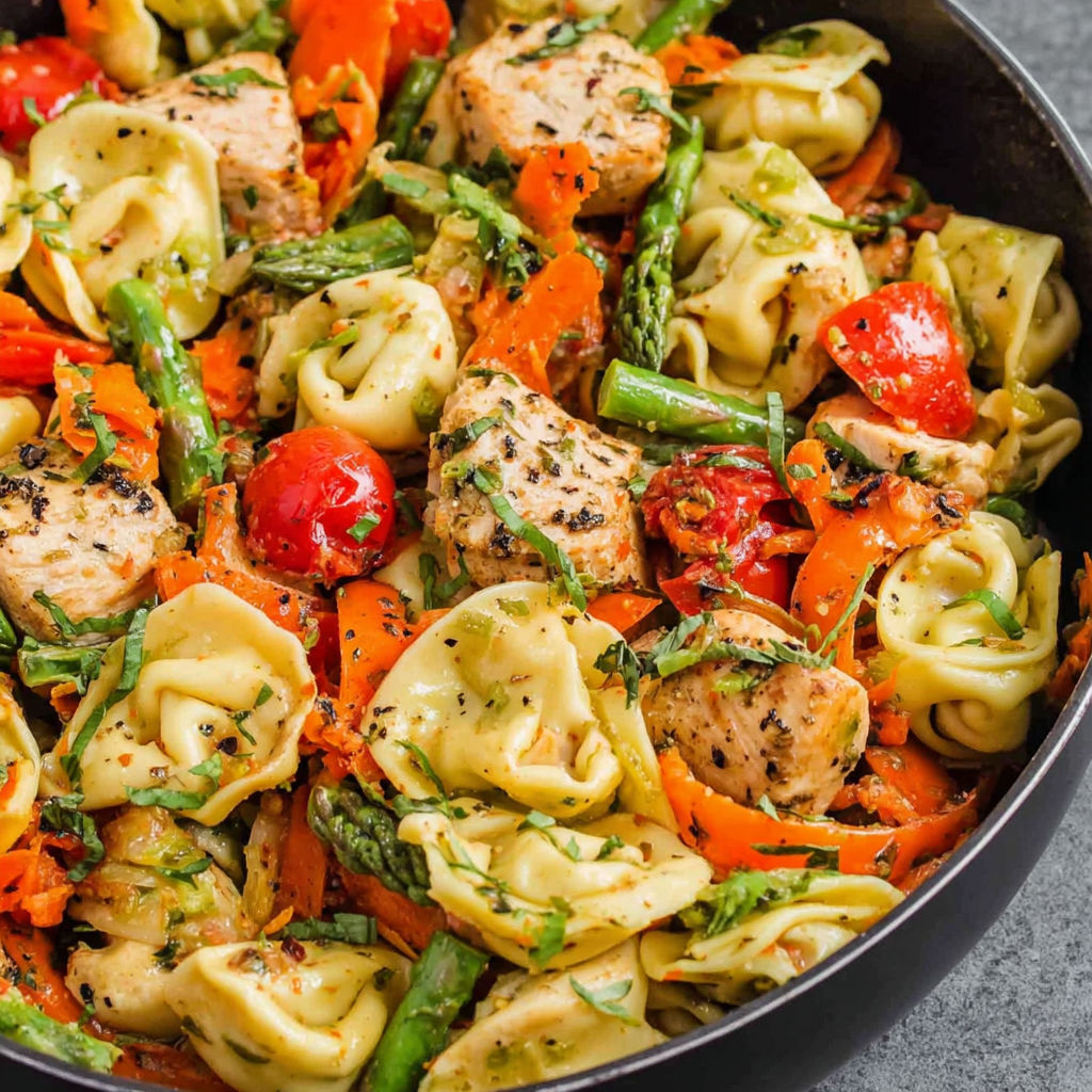 Eine Schüssel Pasta mit Huhn und Gemüse.