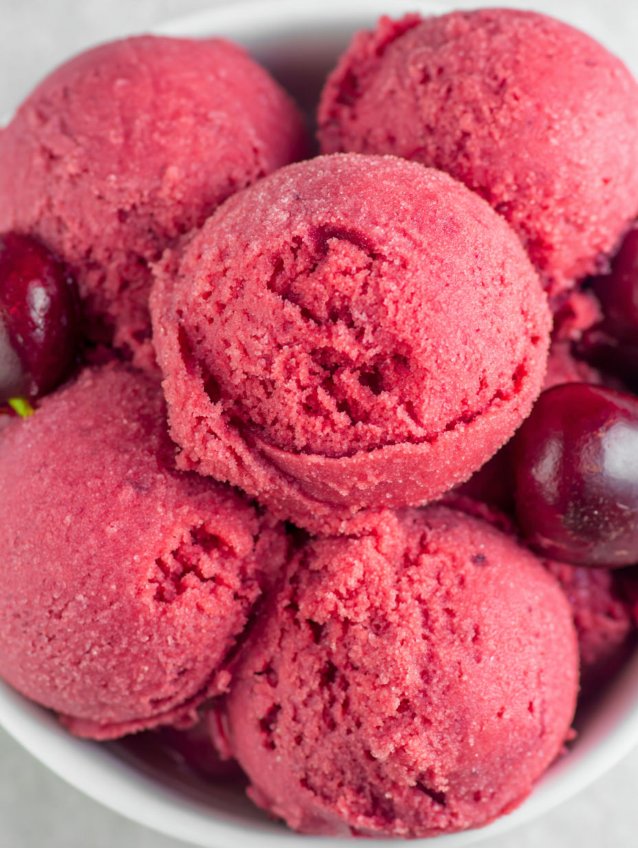 Eine Schale Kirsch-Sorbet mit Kirschstückchen.