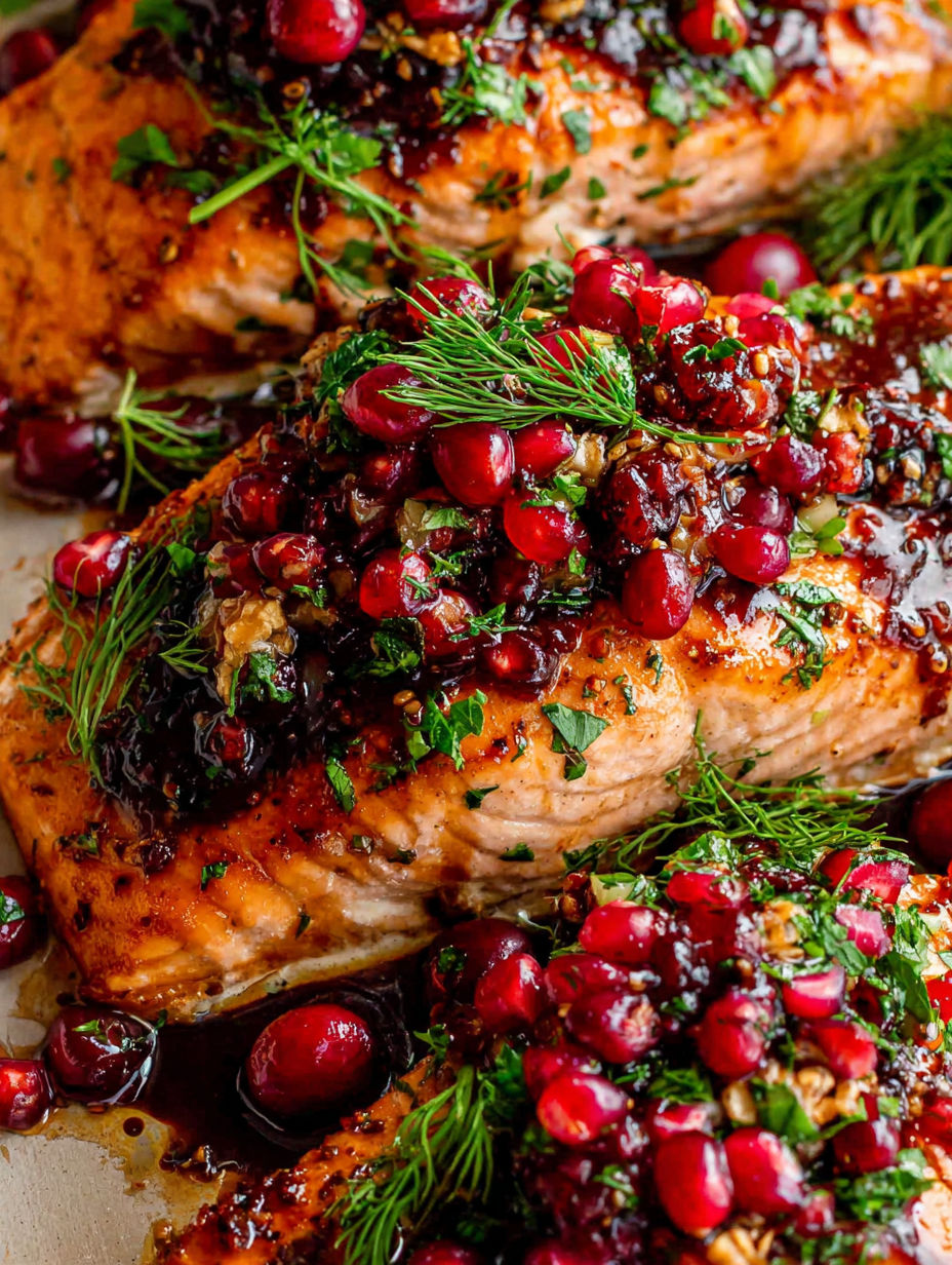 Eine Nahaufnahme eines Lachsstücks mit Sauce obendrauf.