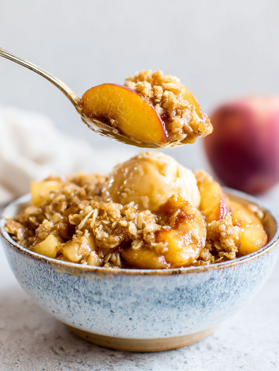 Eine Schüssel mit Pfirsich Crisp und einem Löffel darin.