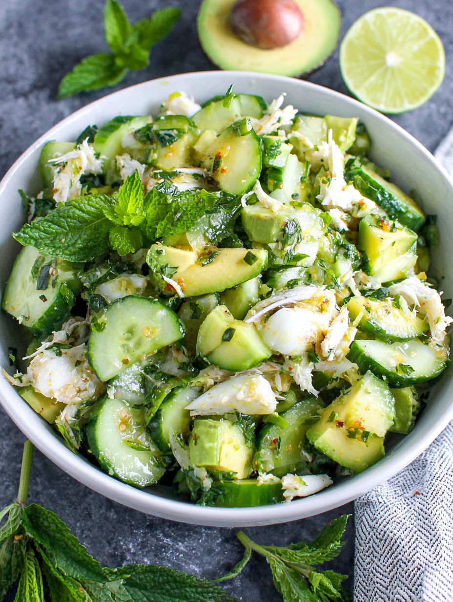 Eine Schüssel mit Gemüse, darunter Gurken, Avocado und Limette.