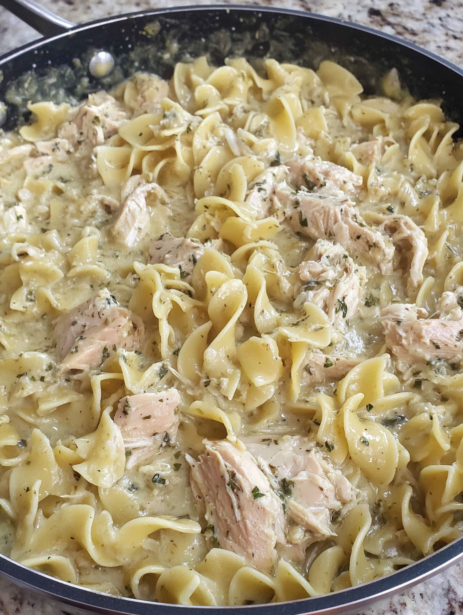 A bowl of creamy cafeteria noodles with chicken.