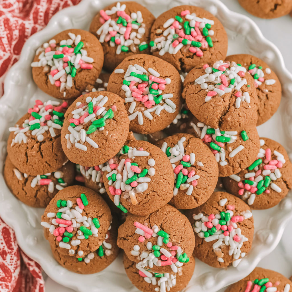 A plate of gingerbread cookies with white and green sprinkles.