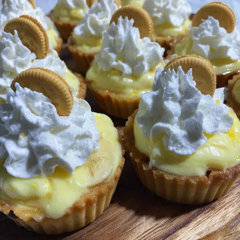 Bananen-Creme-Törtchen mit weißer Schlagsahne.