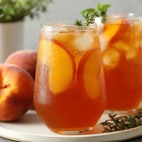 Zwei Gläser Eistee mit darin enthaltenen Pfirsichen.