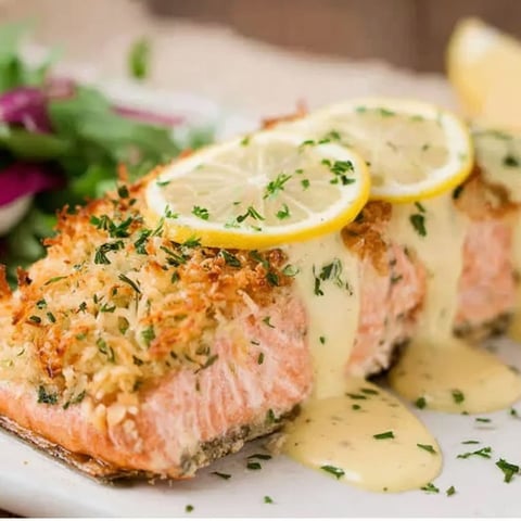 Ein Teller mit gebackenem Lachs und Zitronencremesauce.