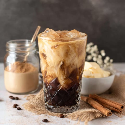 Ein Glas Eiskaffee mit braunem Zucker und Hafermilch.