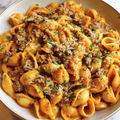 A bowl of pasta with meat and cheese.