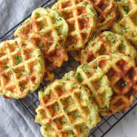A plate of waffles with green toppings.