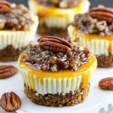 Mini pecan pie cheesecakes with a caramel sauce.