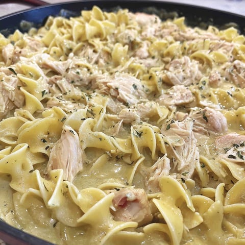 A dish of noodles with chicken and cream sauce.
