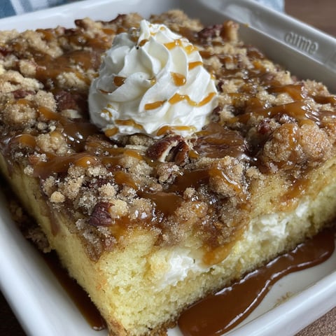 A slice of cake with a dollop of whipped cream on top.