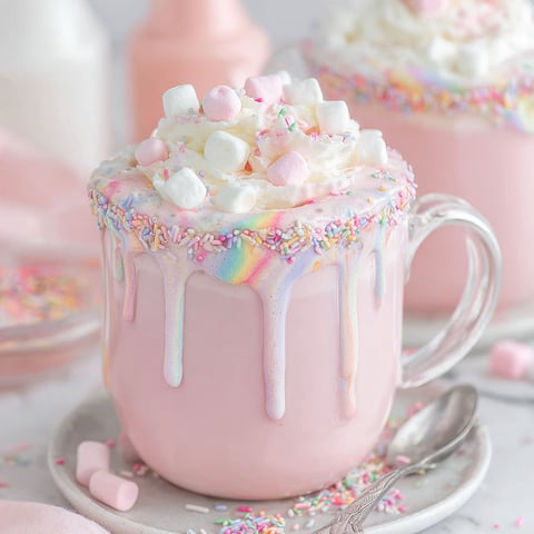 A pink cup of Unicorn Hot Chocolate with marshmallows.