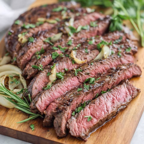 A London Broil steak with onions and herbs.