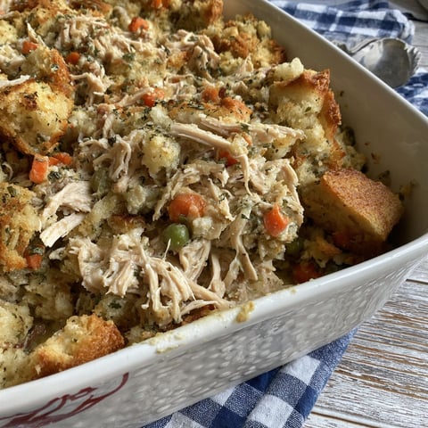 A white bowl filled with chicken and stuffing.