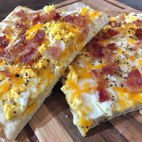 A breakfast pizza with bacon and cheese.