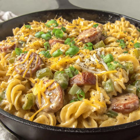 A skillet filled with cheddar sausage and pasta.